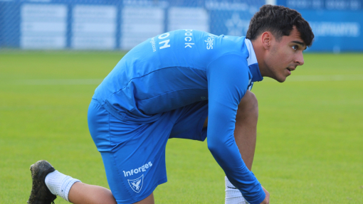 Xente calentando sobre el césped del Heredia 21 La Condomina