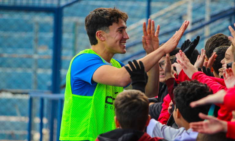 Sevila saludando a los alumnos del colegio en las gradas