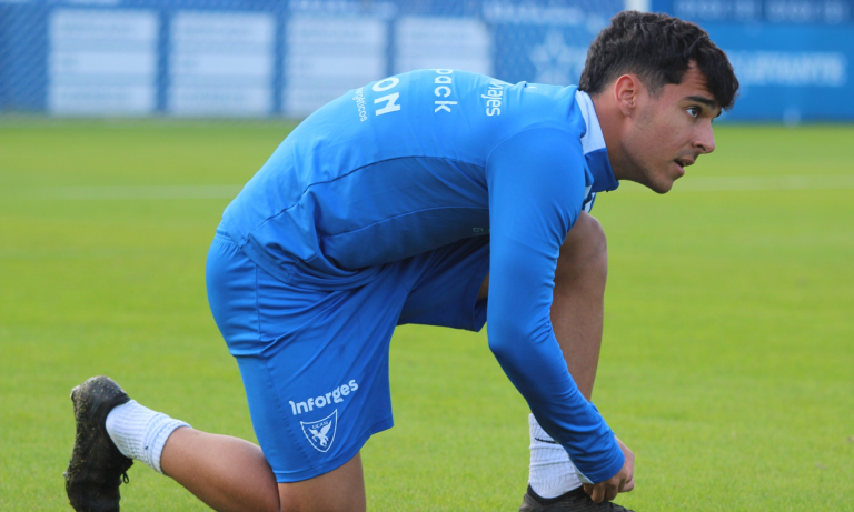 Xente calentando sobre el césped del Heredia 21 La Condomina